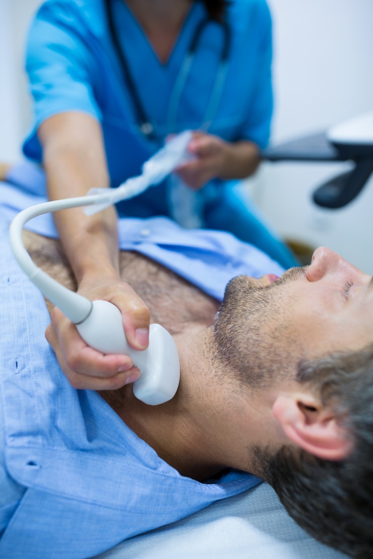 Foto grátis homem que começ o ultra-som de um tiróide de médico