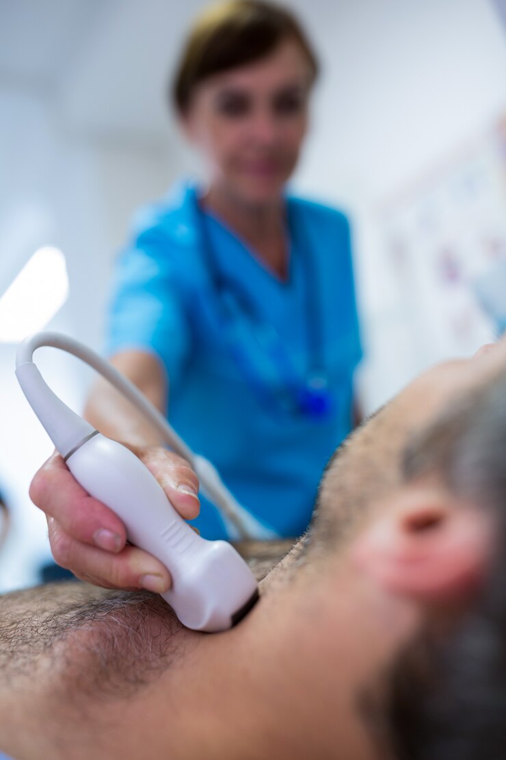 Foto grátis homem que começ o ultra-som de um tiróide de médico