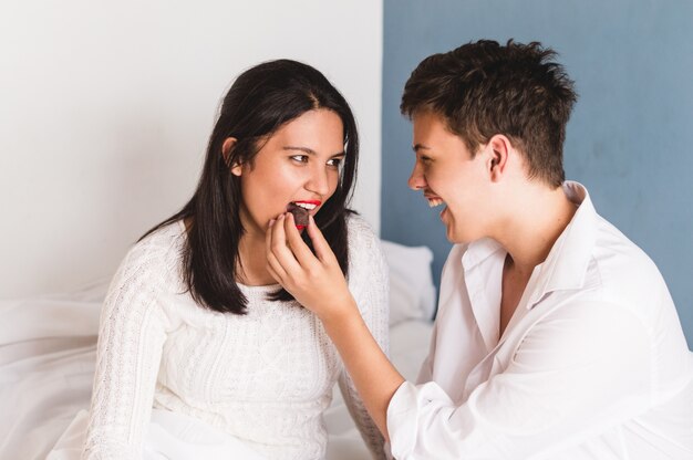 Homem que dá um doce para sua namorada na boca