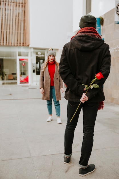 Homem que espera namorada com rosa