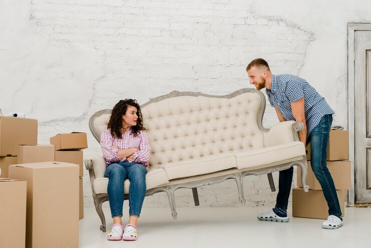 Foto grátis homem que move o sofá com mulher sentada