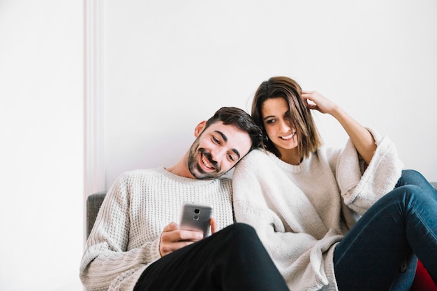 Homem que navega no smartphone perto da mulher