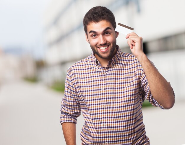 Homem que prende o braço para cima mostrando cartão de plástico.