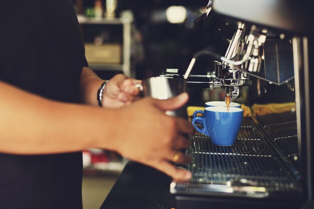 Homem que serve uma xícara de café