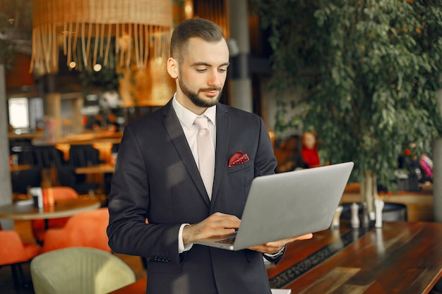 Homem que trabalha com um laptop na mesa