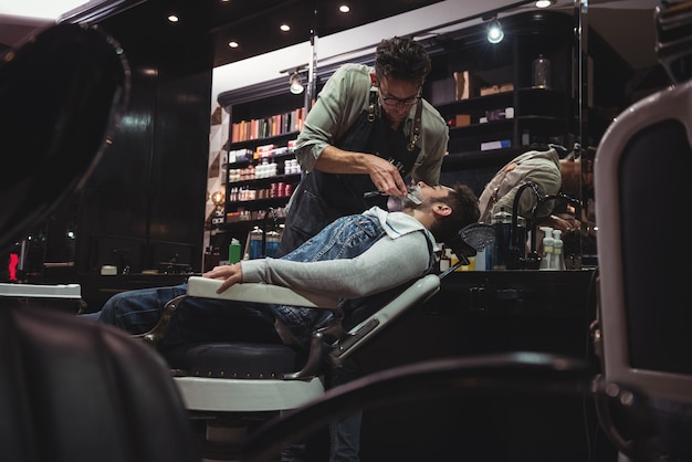 Foto grátis homem raspando a barba com navalha