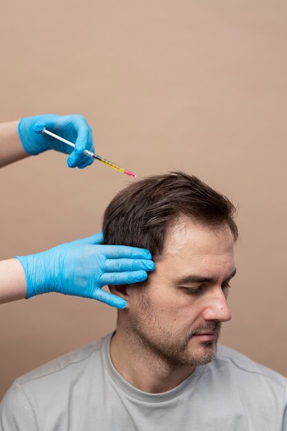 Homem recebendo injeção de prp para alopecia