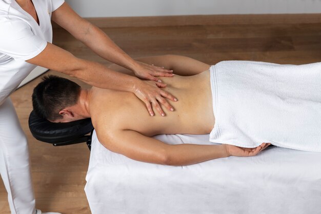 Homem recebendo massagem durante uma sessão de fisioterapia