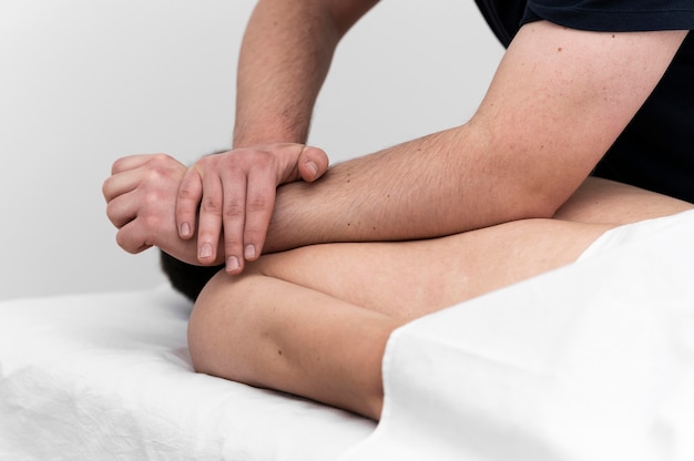 Homem recebendo massagem nas costas do fisioterapeuta