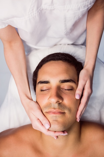 Homem recebendo uma massagem facial na clínica