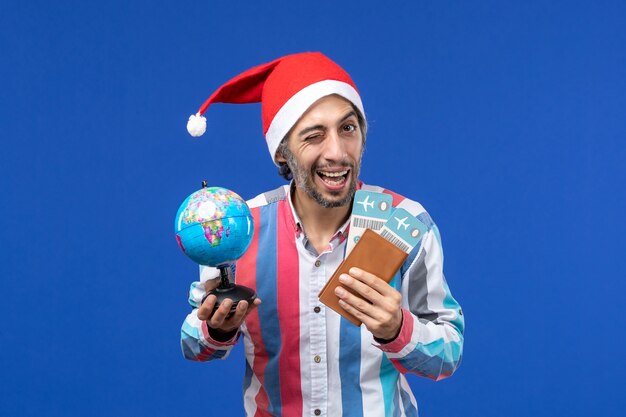 Homem regular de vista frontal com ingressos e globo no piso azul feriado de ano novo