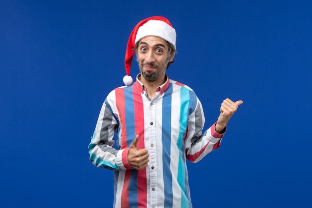 Homem regular de vista frontal com tampa vermelha de natal no piso azul feriado do papai noel