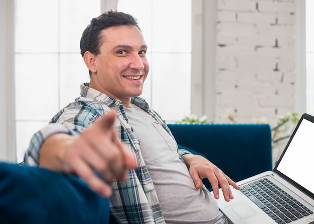 Homem relaxado usando laptop em casa