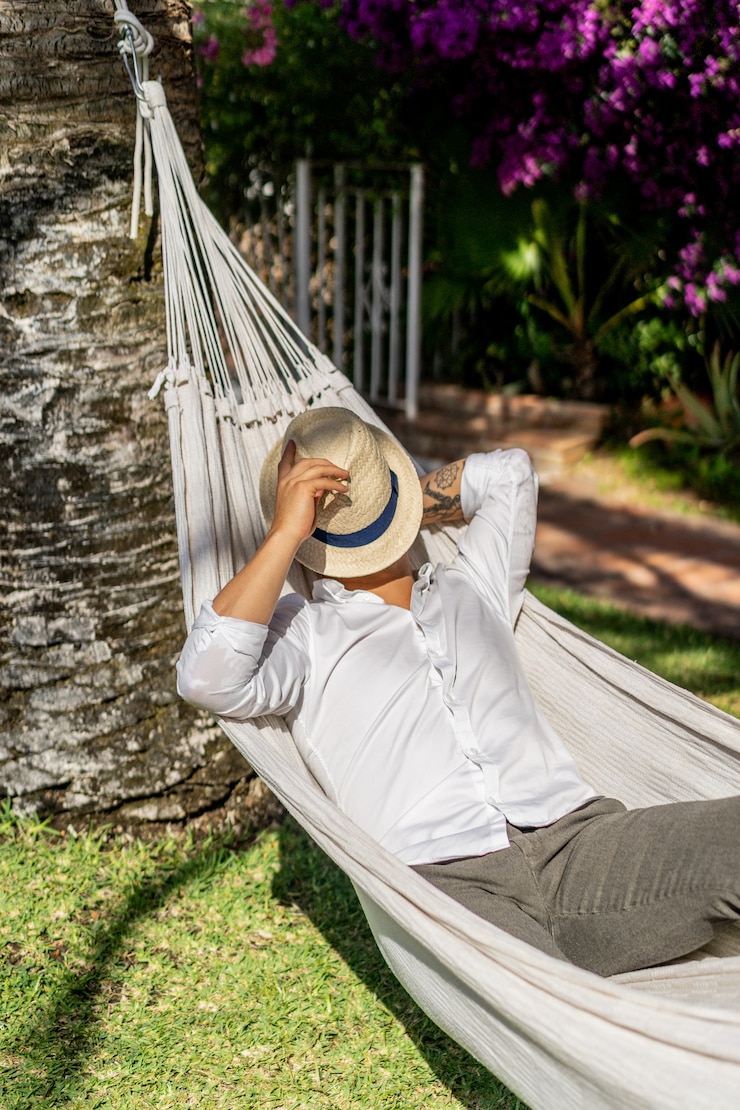 Foto grátis homem relaxando em uma rede no jardim.