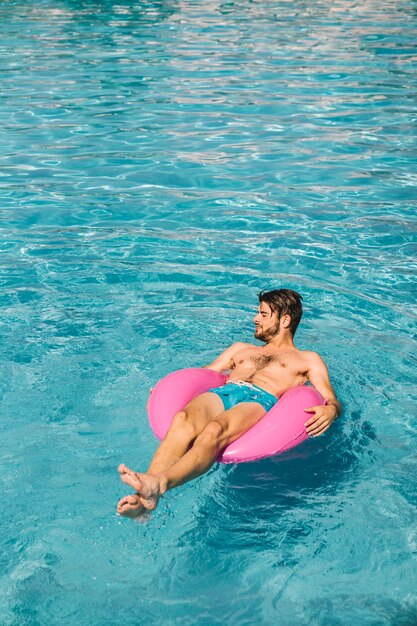 Homem relaxante no anel de ar inflável