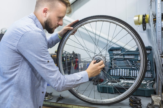 Homem, reparar, roda, de, bicicleta, em, oficina