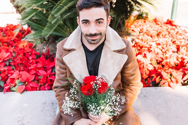 Homem satisfeito com flores nas mãos