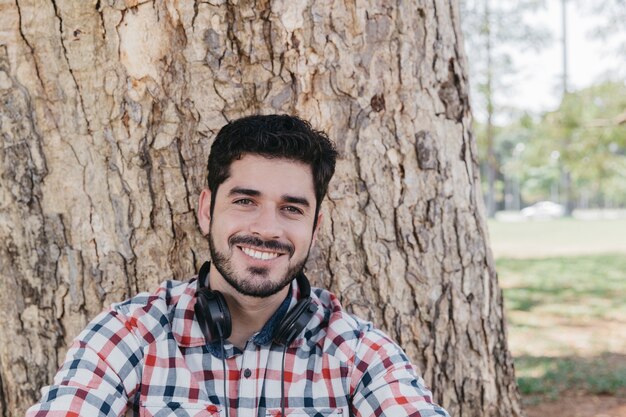 Homem satisfeito posando na câmera em fones de ouvido