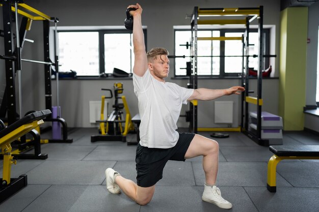 Foto grátis homem se exercitando com kettlebell tiro completo