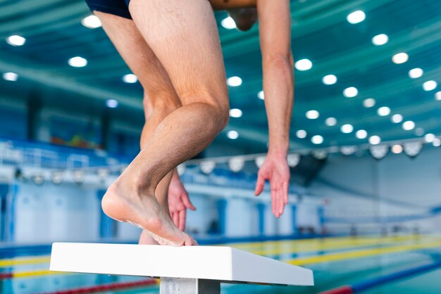 Homem se preparando para pular na piscina