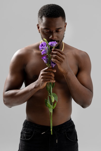 Homem segurando a vista frontal da flor roxa