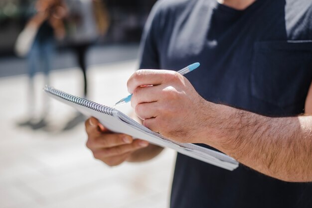 Homem, segurando, caderno, escrita