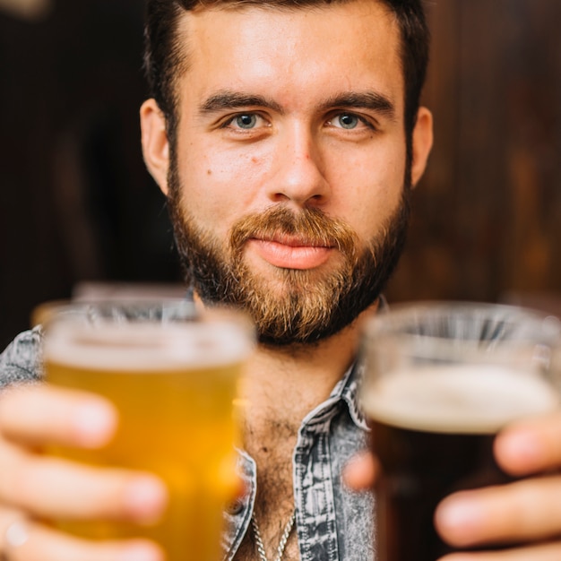 Foto grátis homem, segurando, copos cerveja, e, rum, olhando câmera