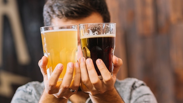 Homem, segurando, copos, de, rum, e, cerveja, frente, seu, rosto