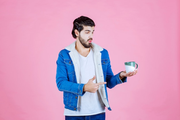 Homem segurando e promovendo uma xícara de café ou café