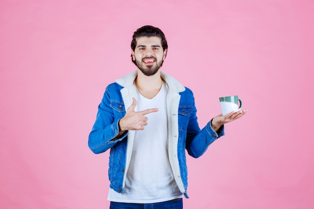 Homem segurando e promovendo uma xícara de café ou café