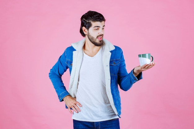 Homem segurando e promovendo uma xícara de café ou café