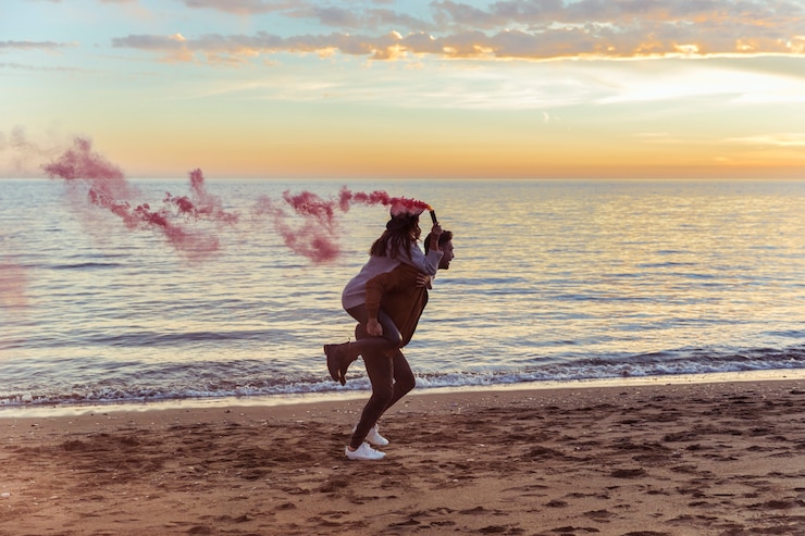Foto grátis homem, segurando, mulher, com, cor-de-rosa, bomba fumaça, ligado, costas