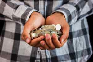 Foto grátis homem segurando nas mãos de poupar moedas