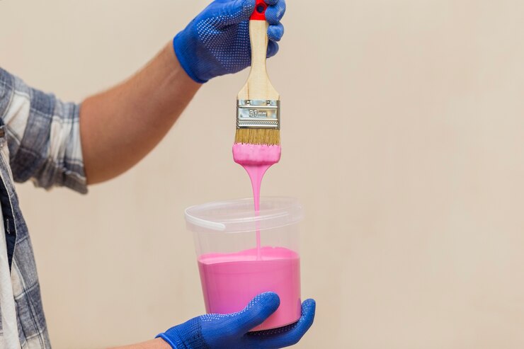 Foto grátis homem segurando nas mãos um pincel e tinta rosa