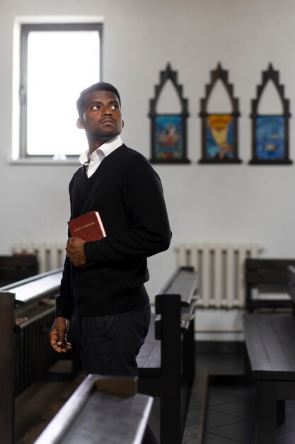 Homem segurando o livro bíblico na igreja