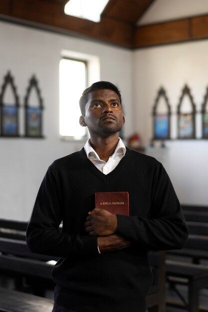 Homem segurando o livro bíblico na igreja