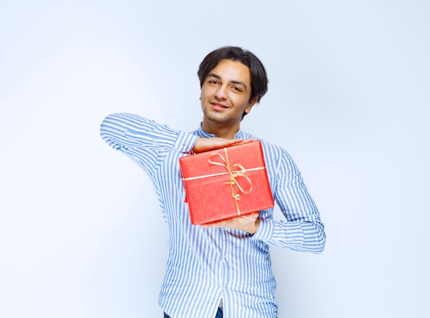 Homem segurando ou oferecendo uma caixa vermelha de presente para a namorada. Foto de alta qualidade