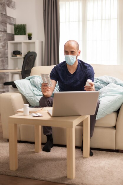 Homem segurando pílulas diferentes durante a consulta online com o médico em quarentena.