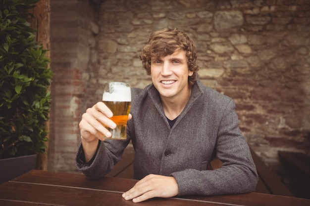 Homem segurando um copo de cerveja