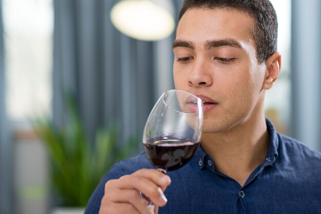 Homem segurando um copo de vinho tinto com espaço de cópia