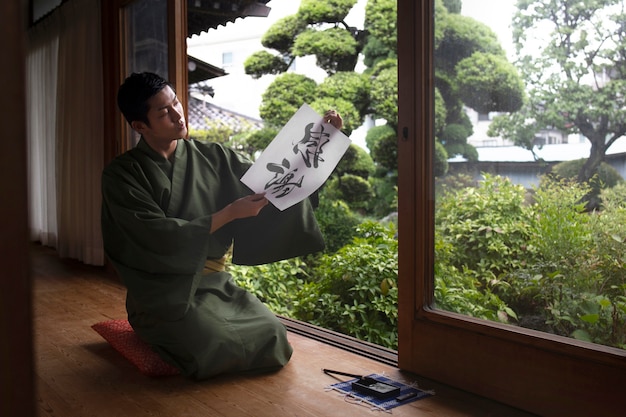 Homem segurando um papel com caligrafia japonesa