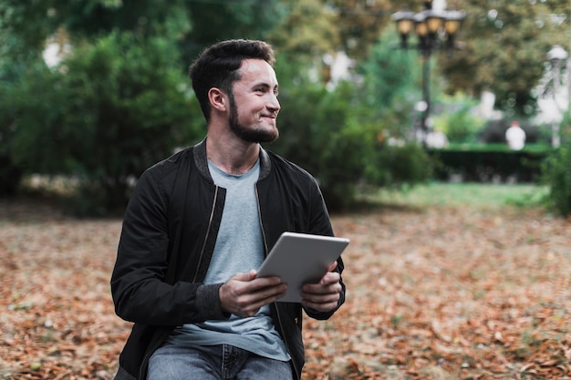 Homem segurando um tablet e desviar o olhar