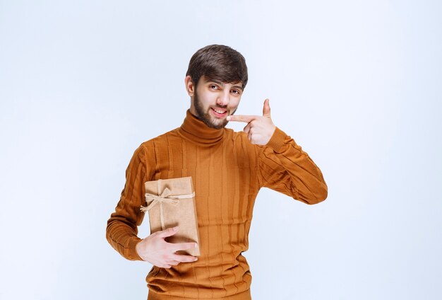 Homem segurando uma caixa de papelão e apresentando-a