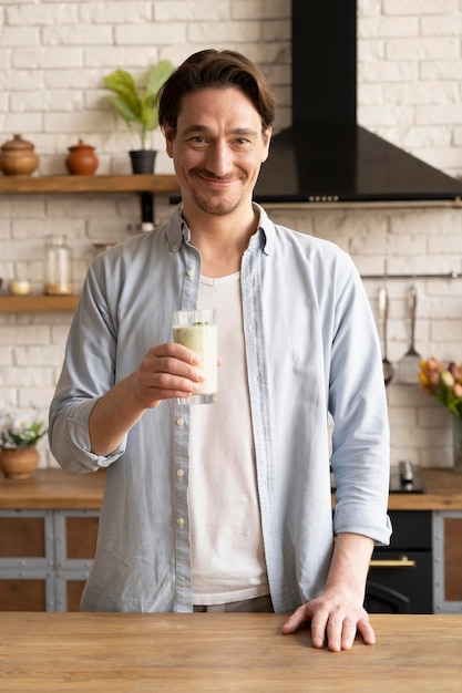 Foto grátis homem segurando uma dose média de suco de leite