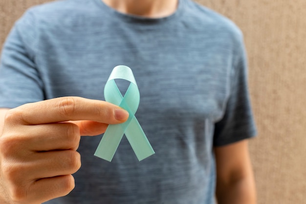Homem segurando uma fita azul. a saúde dos homens. novembro azul. mês de prevenção do câncer de próstata. Foto Premium