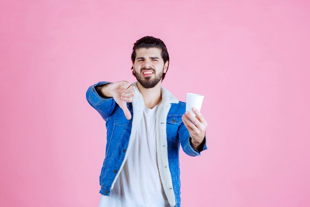 Homem segurando uma xícara de café e não gosta dela