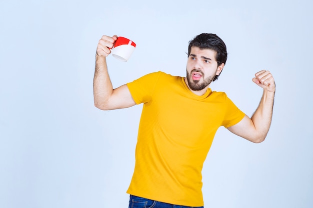 Homem segurando uma xícara de café e se sentindo poderoso.