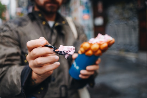 Homem segurando waffle de bolha de caminhão de comida de rua