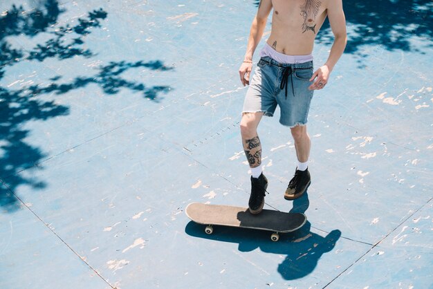 Homem sem camisa com skateboard