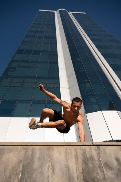 Homem sem camisa praticando parkour ao ar livre